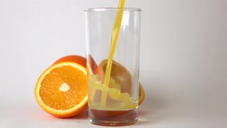 超级慢动作拍摄切成薄片将整个橙汁和橙汁倒入玻璃杯中